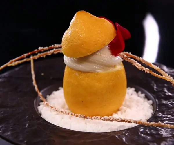 Chef de cuisine en train de dresser un plat avec précision du restaurant La Table des Trois à Bordeaux